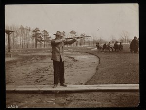 Frank Work visant un fusil à un tir au piège, New York, 1896 - Byron Company